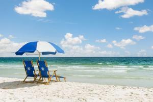 duas cadeiras e um guarda-sol numa praia em Hyatt Place Panama City Beach - Beachfront em Panama City Beach
