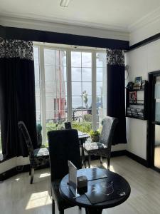 a living room with a table and chairs and a window at Edelweiss Guest House in Douglas