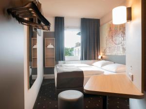 シュヴェリーンにあるB&B Hotel Schwerin-Südのベッド2台とテーブルが備わるホテルルームです。