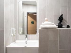 a bathroom with a sink and a mirror at B&B Hotel Schwerin-Süd in Schwerin