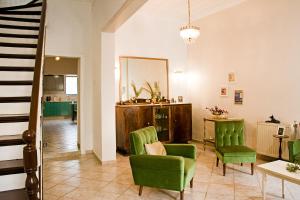 sala de estar con sillas verdes y mesa en Lilian's House en La Canea