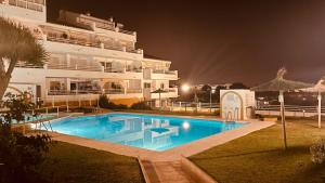 een zwembad voor een groot gebouw 's nachts bij Seaview Apartment Mira Andalus in Sitio de Calahonda