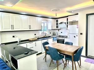 een keuken met witte kasten en een houten tafel bij Marmara luxury villa in Marmaraereglisi