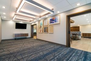 a meeting room with a flat screen tv and a hallway at Holiday Inn Express & Suites - Springdale - Fayetteville Area in Springdale