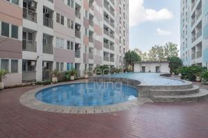 - une piscine au milieu d'un bâtiment dans l'établissement RedLiving Apartemen Grand Sentraland - Dragon Apartel Tower Pink, à Karawang