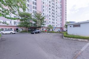 a parking lot in front of a large building at RedLiving Apartemen Grand Sentraland - Dragon Apartel Tower Pink in Karawang