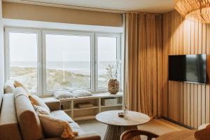uma sala de estar com um sofá e duas janelas em BONK suites em Middelkerke