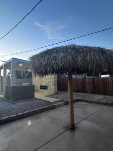 a straw umbrella in front of a building at Charming and Cozy Place in Las Vegas