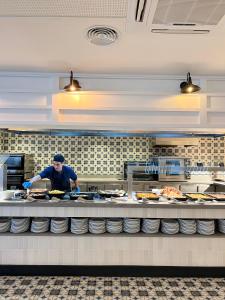 a man preparing food in a restaurant kitchen at Gran Hotel Flamingo-Adults Only older 18 years old in Lloret de Mar