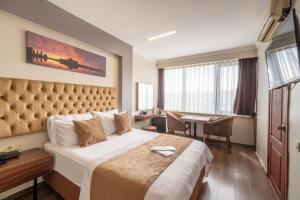 イスタンブールにあるIstanbul Nova Hotelの大きなベッドとデスクが備わるホテルルームです。