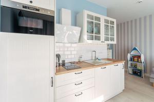 a kitchen with white cabinets and a sink at Comfortable 2 room apartment only 450 m from the beach Grzybowo in Grzybowo