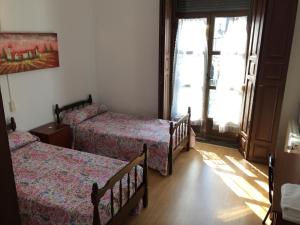 um quarto com 2 camas e uma janela em Pension Carretero em Cáceres