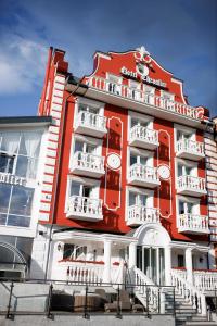 a red building with white balconies on the side of it at Chevalier Hotel & SPA in Bukovel