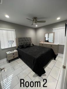 a bedroom with a black bed and a mirror at Charming and Cozy Place in Las Vegas
