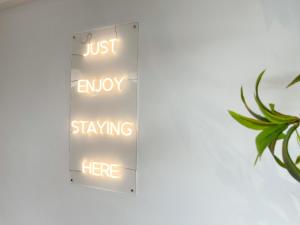 a sign that says just enjoy staying here at Sleep Box Penang in George Town