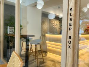 a dining room with a table and a glass window at Sleep Box Penang in George Town