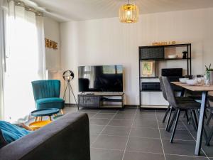 - un salon avec une télévision, une table et des chaises dans l'établissement La Belle Vue - Garage Terrasse Wi-Fi Netflix Disney+, à Annecy
