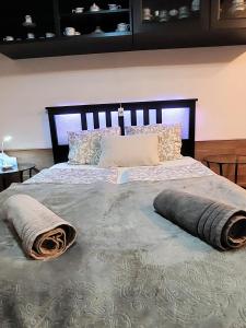 um quarto com uma cama grande com almofadas em GaLiBa Vendégház em Jenő
