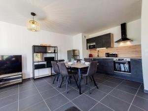 a kitchen with a table and chairs in a room at La Belle Vue - Garage Terrasse Wi-Fi Netflix Disney+ in Annecy