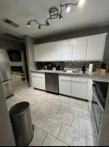 a kitchen with white cabinets and a tile floor at Charming and Cozy Place in Las Vegas +4 photos