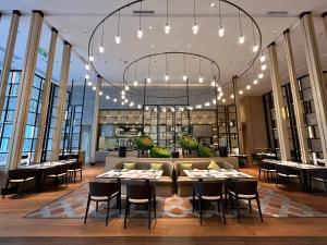 a restaurant with tables and chairs and a large chandelier at The Westin Wuhan Hanyang in Wuhan