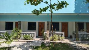 a house with two white benches in front of it at ELEN INN - Malapascua Island FAN ROOM #2 in Malapascua Island