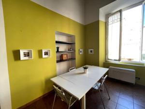 a dining room with a table and a yellow wall at Loft storico in pieno centro! in Livorno