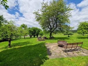 a park with benches and trees in a field at Kötterhof in Bevern