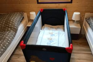 a baby crib in a room with two beds at Leisure complex with a swimming pool Jezierzany in Jezierzany
