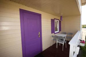 a purple door on the side of a house with a table at Leisure complex with a swimming pool Jezierzany in Jezierzany