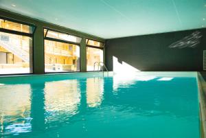 a swimming pool with blue water in a house at Résidence Lagrange Vacances Le Pic de l'Ours in Font-Romeu