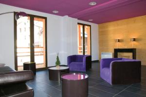 sala de estar con muebles de color púrpura y chimenea en Lagrange Vacances Le Pic de l'Ours en Font Romeu