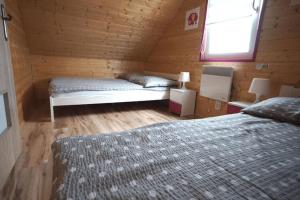 a bedroom with two beds in a wooden cabin at Leisure complex with a swimming pool Jezierzany in Jezierzany