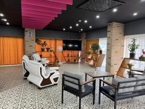 - un hall avec des chaises, des tables et une télévision dans l'établissement Nobel Boutique Hotel, à Selçuk