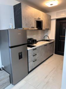 a kitchen with a stainless steel refrigerator and a microwave at Cozy and quiet apartment in Arad