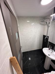 a small bathroom with a sink and a shower at Cozy and quiet apartment in Arad