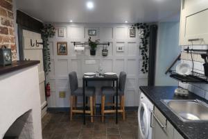 a small kitchen with a table and chairs in it at The Old Pantry at Hill Farm in Penley