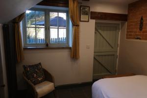 um quarto com uma cama, uma janela e uma porta em The Old Pantry at Hill Farm em Penley