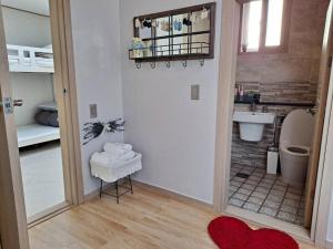 a bathroom with a toilet and a sink and a mirror at Dongpirang Purple House 2 in Tongyeong