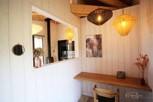 a room with a counter and two lights and a mirror at les Hauts de Rébeillou - Cabane Spa in Flourens