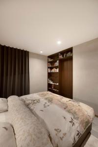 een slaapkamer met een groot bed en een boekenplank bij Nuit Blanche in Oud-Heverlee
