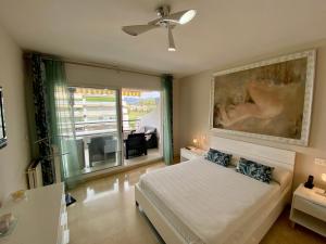 1 dormitorio con 1 cama y una gran pintura en la pared en Apartamento con vistas y terraza en Guadalmina Marbella, en Marbella