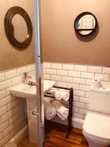 W łazience znajduje się umywalka, toaleta i lustro. w obiekcie No 11 Rooms w mieście Haworth
