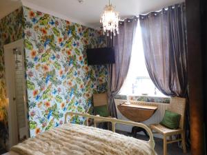sypialnia z łóżkiem i oknem z tapetą w kwiaty w obiekcie No 11 Rooms w mieście Haworth