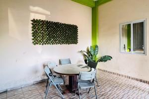 a table and chairs in a patio with a plant at Teratai Residence Mitra RedDoorz in Medan