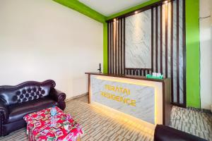 a living room with a leather chair and a sign at Teratai Residence Mitra RedDoorz in Medan