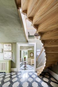 a large hallway with a wooden staircase and a vaulted ceiling at One Shot Palácio Cedofeita in Porto