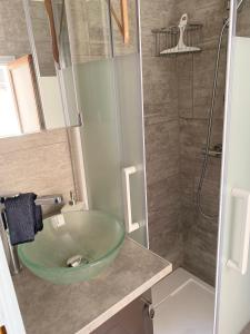 a bathroom with a glass bowl sink in a shower at Maisonnette au cœur du village in Le Bar-sur-Loup