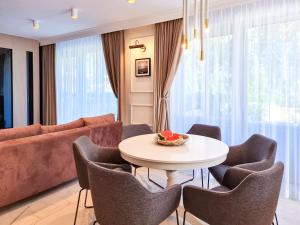 uma sala de estar com uma mesa e cadeiras e um sofá em visit baltic - Apartament Plażowy Casa em Świnoujście