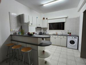 una cocina con encimera y taburetes. en Serena Vacation Home, en Pomos